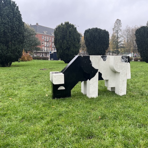 Concrete grazing cow in a park on Albert Neuhuysstraat. Amsterdam, Netherlands.